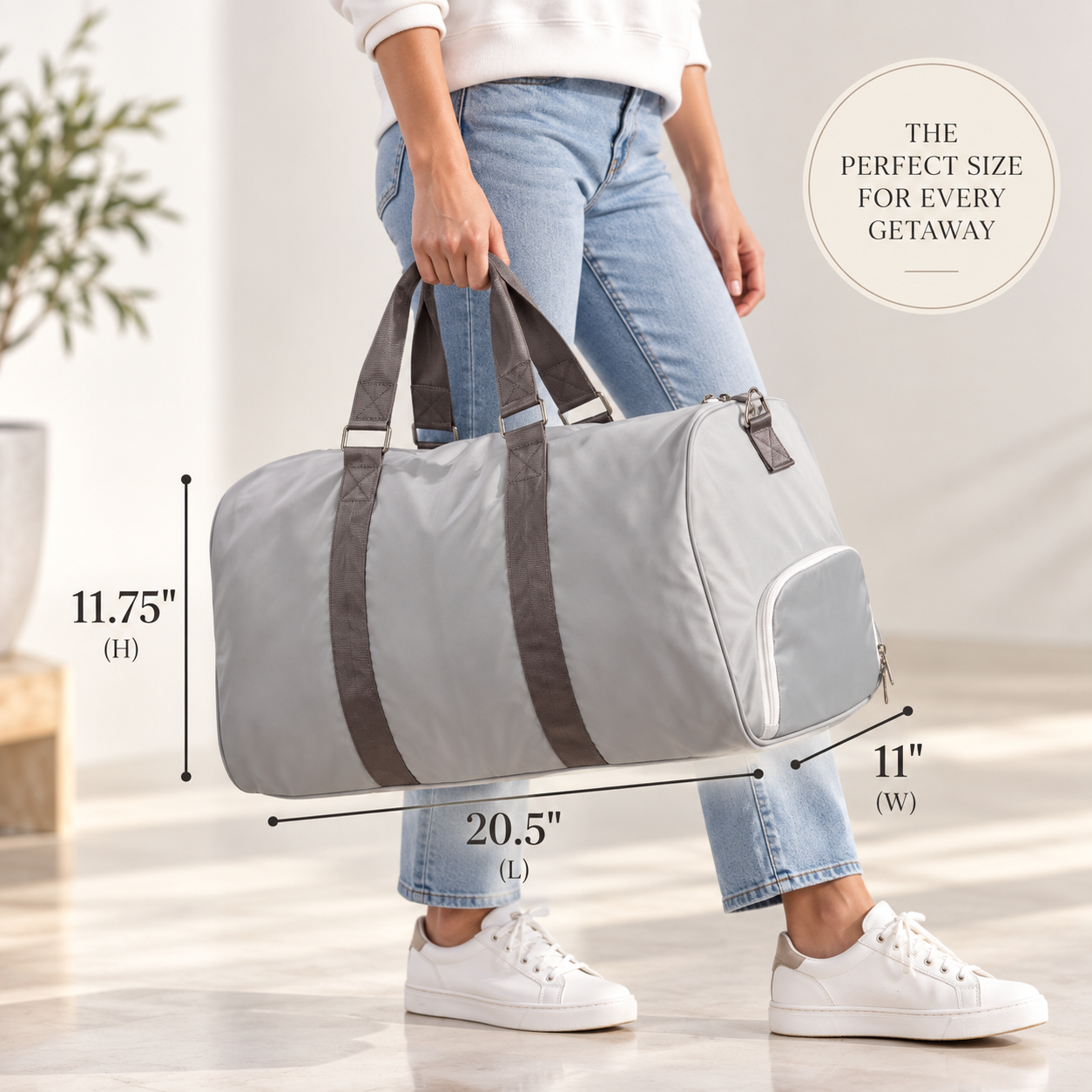 Grey duffle bag worn over one shoulder with dimensions labeled 20.5 inches long, 11.75 inches tall, and 11 inches wide.