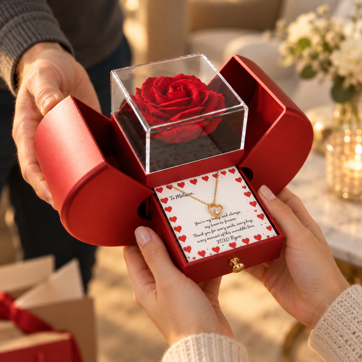A man handing an open red heart-shaped gift box to a woman outdoors, revealing a preserved rose and a personalized heart pendant necklace message card inside.