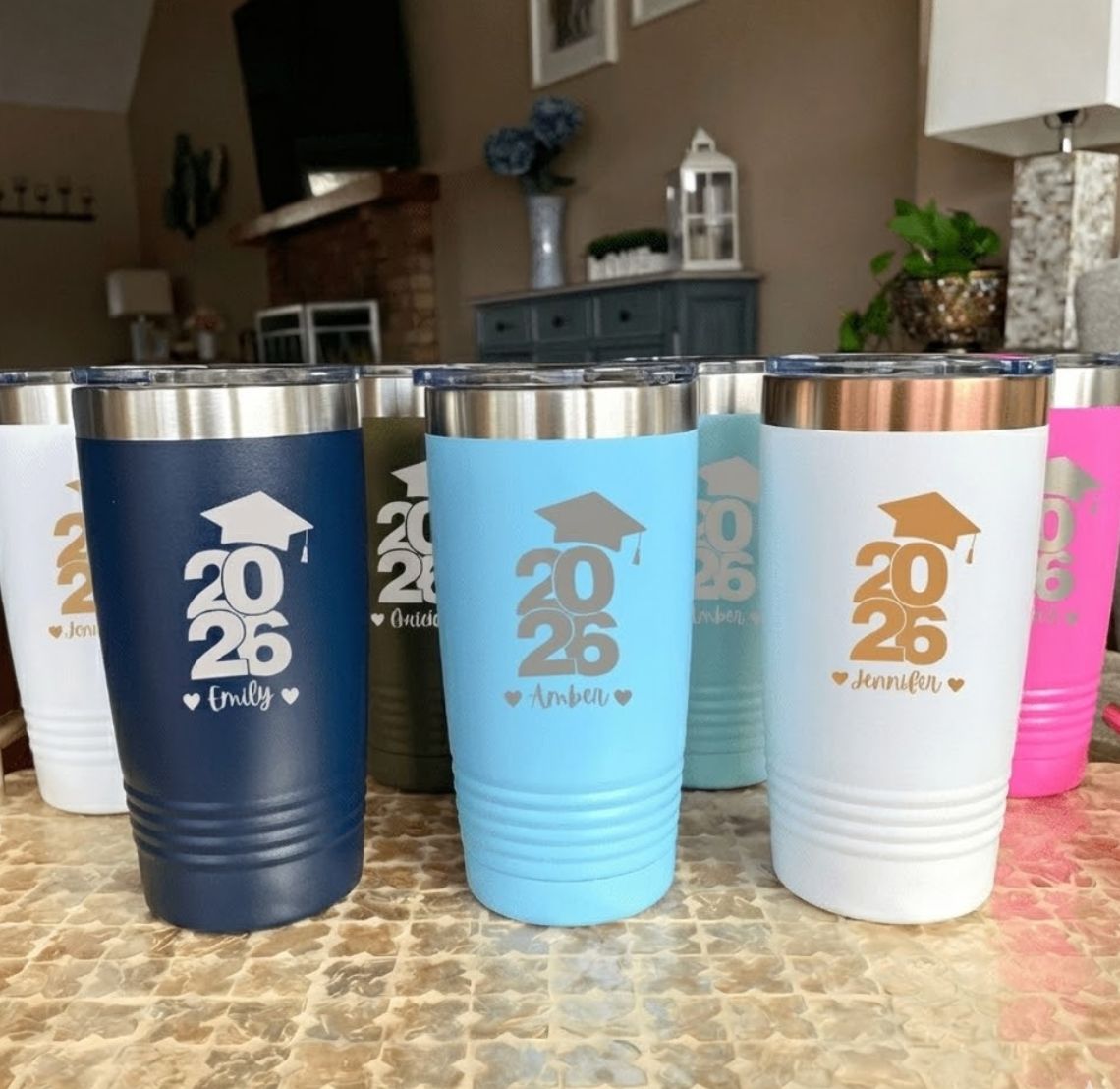 Set of colorful tumblers with 2026 graduation gift designs on a kitchen counter.