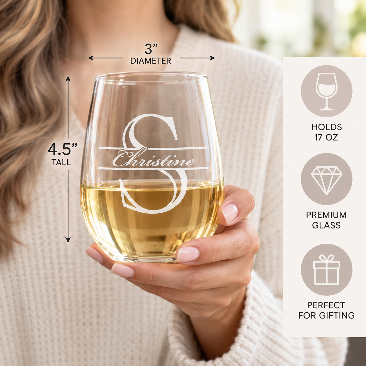Woman holding a personalized stemless wine glass engraved with S and Christine, with size callouts showing 3 inches in diameter, 4.5 inches tall, and a 17 ounce capacity.
