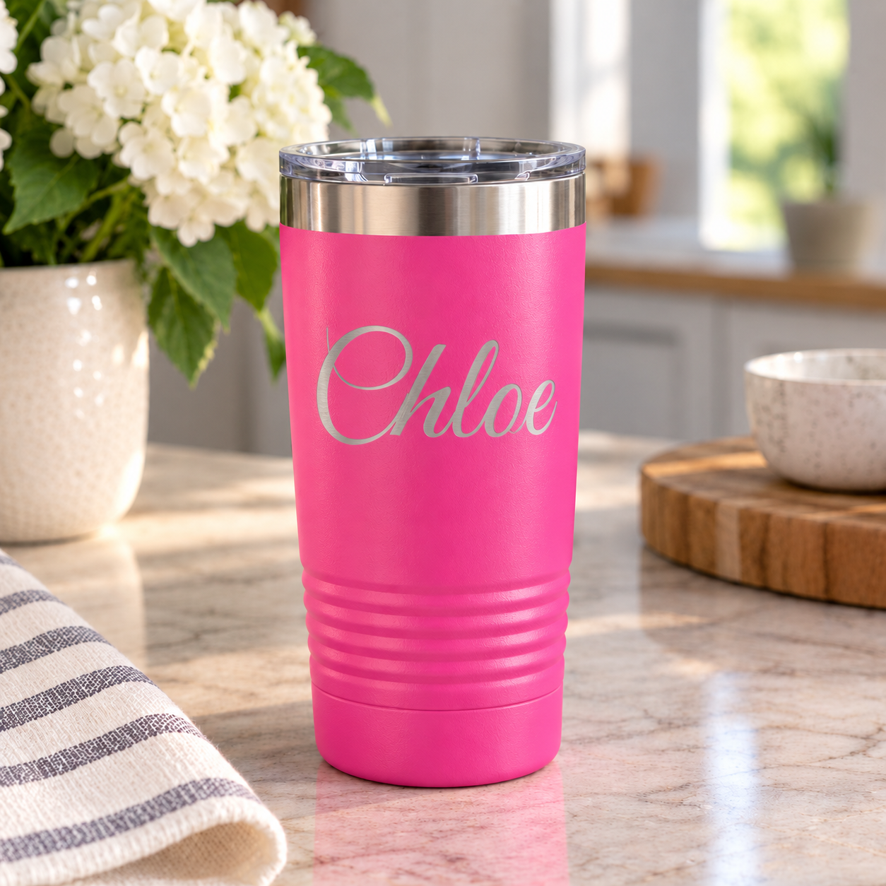 hot pink. tumbler sitting on counter with Chloe laser engraved on it.