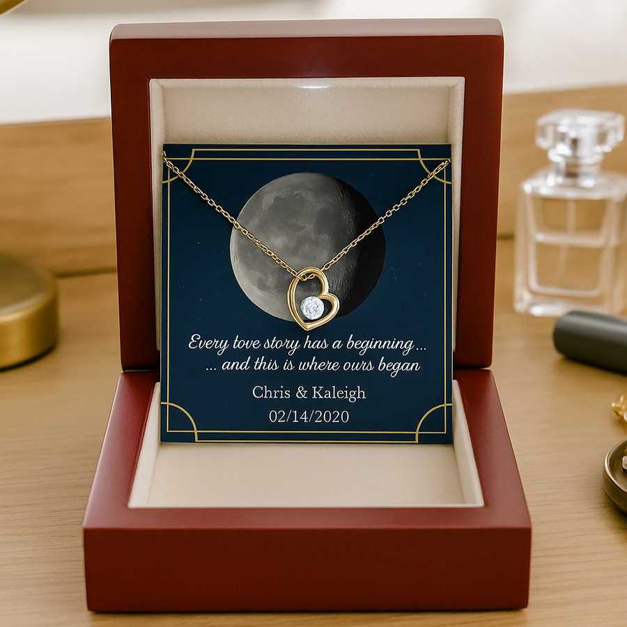 Gold heart necklace with crystal stone displayed in mahogany box showing sample moon phase, personalized with names Chris & Kaleigh and date 02/14/2020
