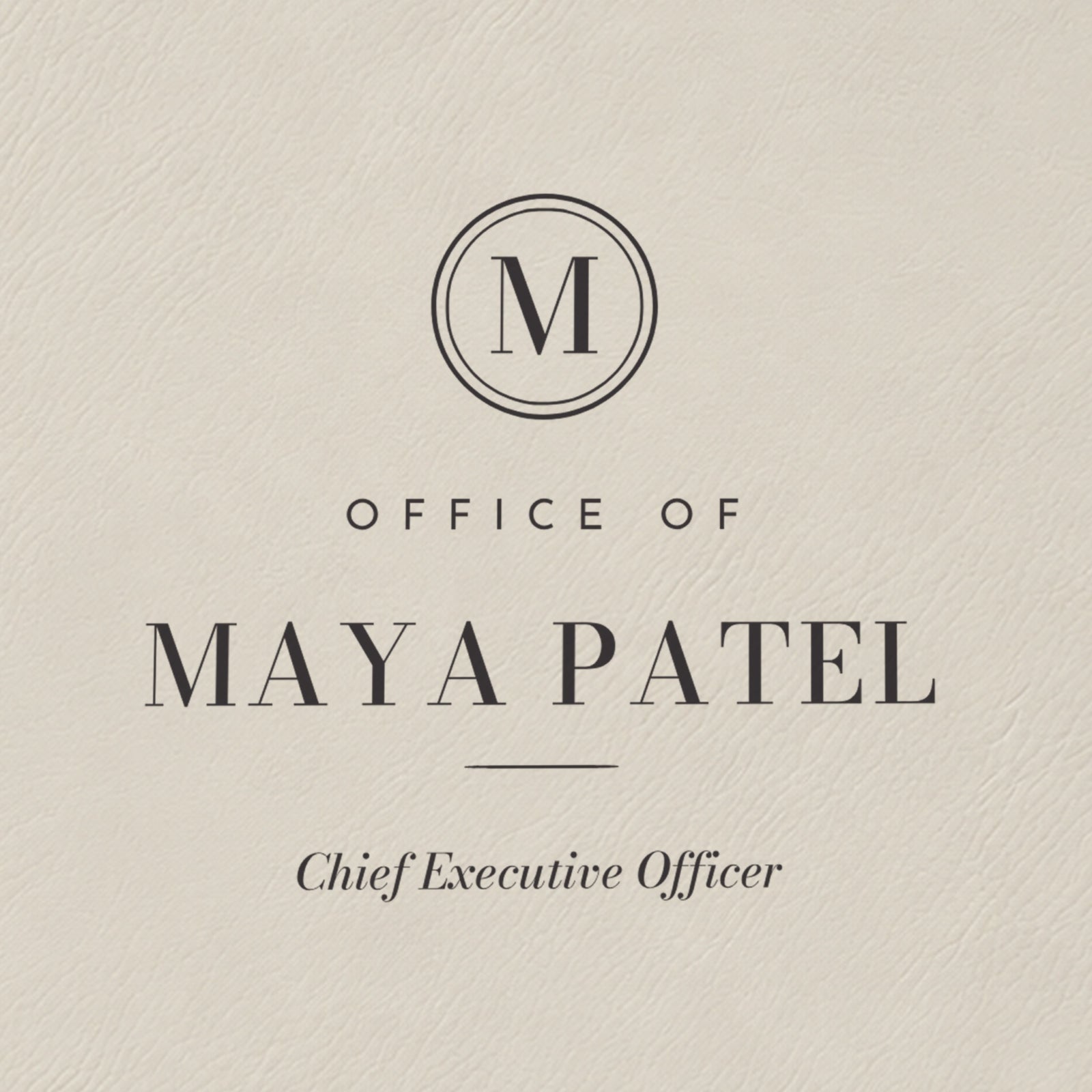 Close-up of the black laser engraving on the white padfolio: M monogram seal, Office of, Maya Patel and Chief Executive Officer in italic