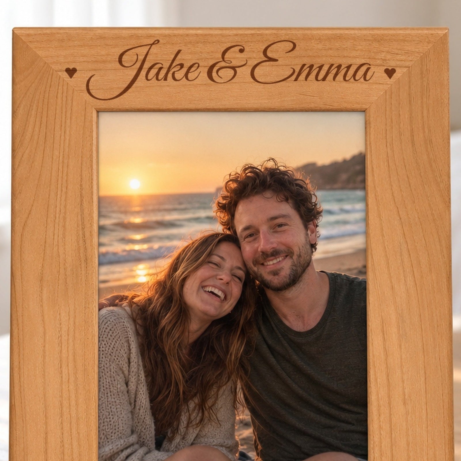 Close-up of the laser engraving on the red alder picture frame: Jake & Emma in script with a heart on each side, burned into the wood