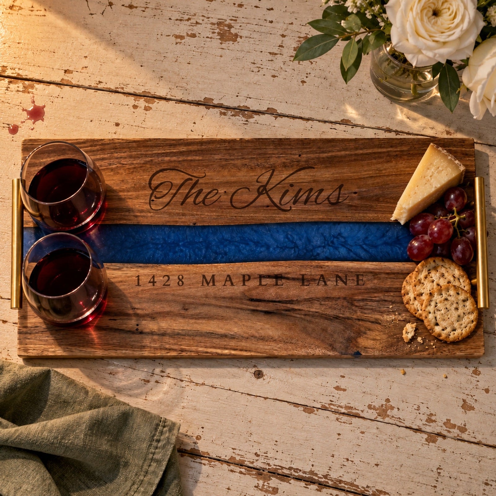 Housewarming gift serving tray engraved The Kims and 1428 Maple Lane, with two glasses of red wine, cheese, grapes and crackers on a farmhouse table