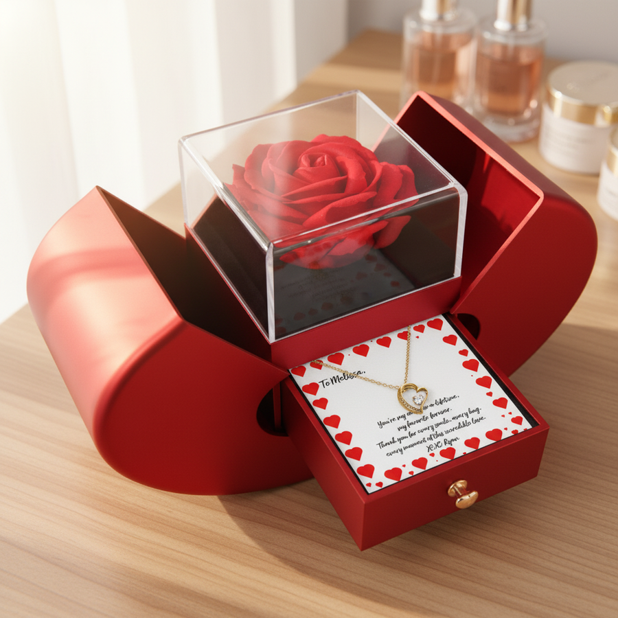 Red heart-shaped box with preserved rose under clear dome lid, gold heart necklace visible on card with red heart border and sample personalization text
