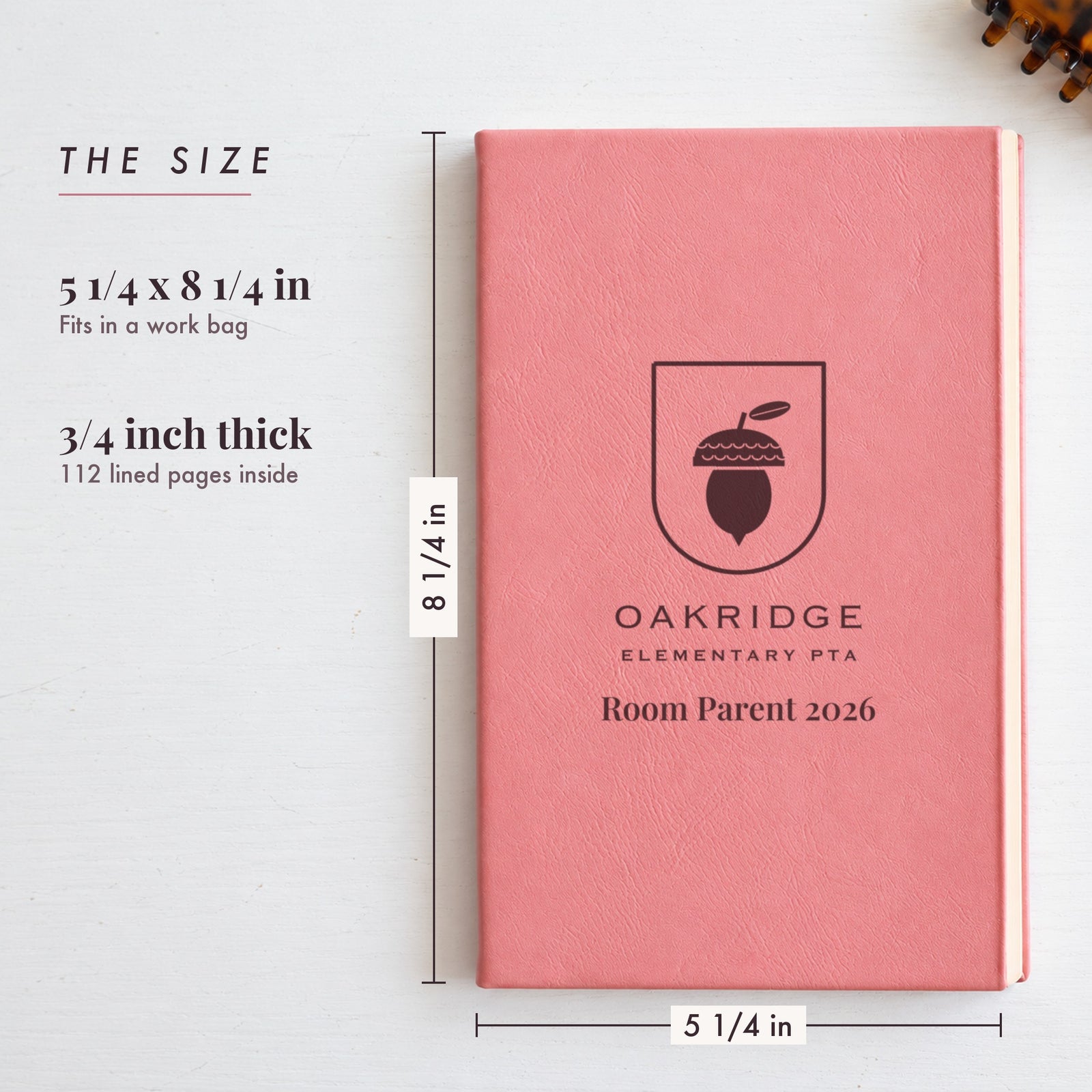 Size of the engraved logo journal, 5 1/4 by 8 1/4 inches and 3/4 inch thick, shown on a pink cover with a school PTA acorn logo and Room Parent 2026