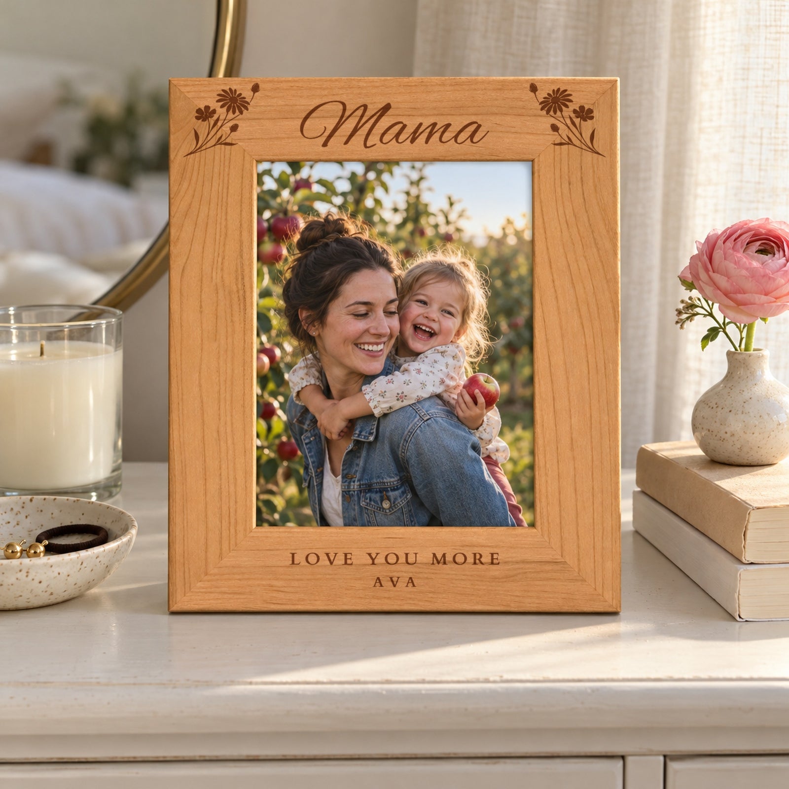 Engraved wood mom picture frame reading Mama with Love You More and Ava on a white bedroom dresser, holding a photo of a mom and toddler daughter in an apple orchard
