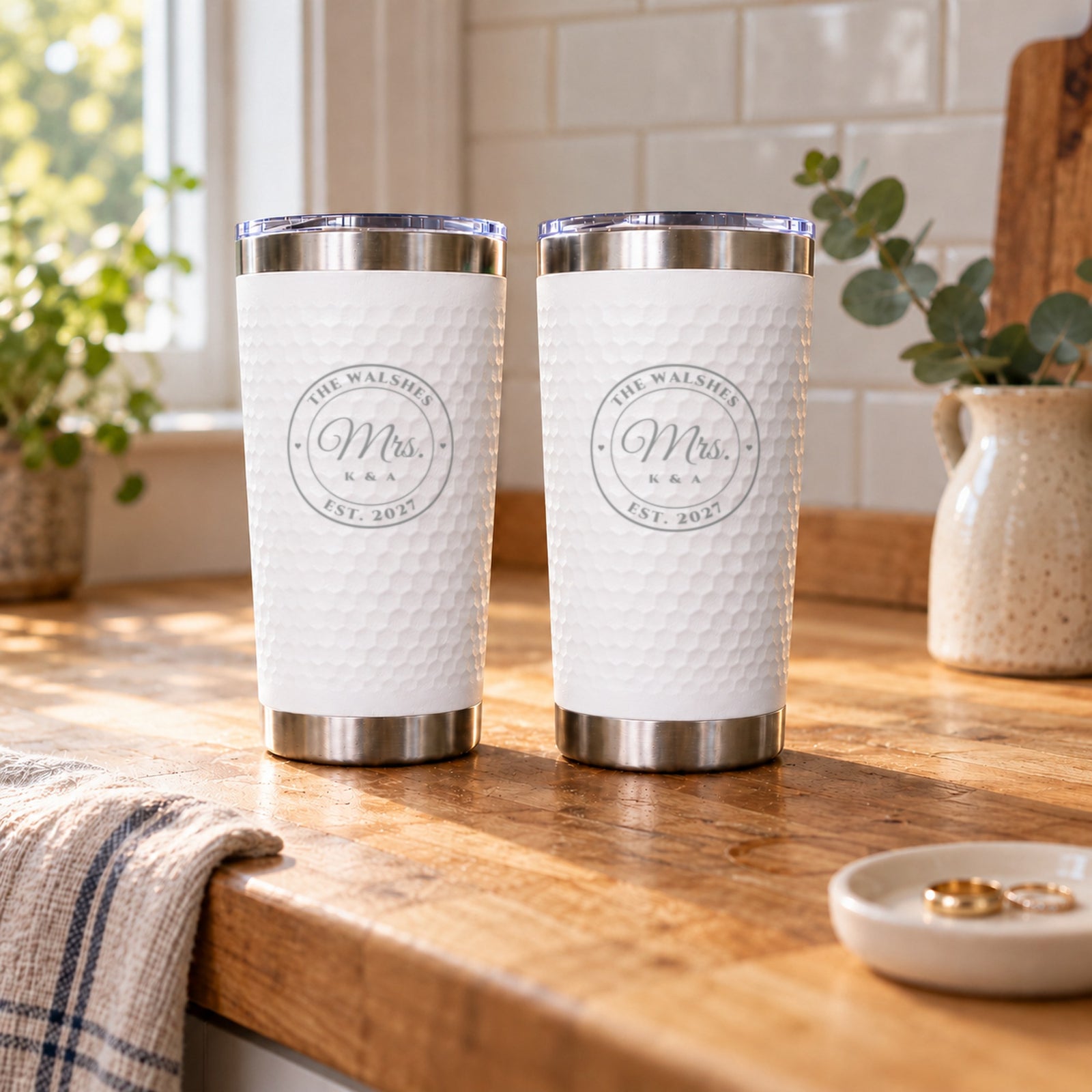 Two white engraved tumblers reading Mrs. and Mrs. for The Walshes, Est. 2027, the white and white color choice of the couples set