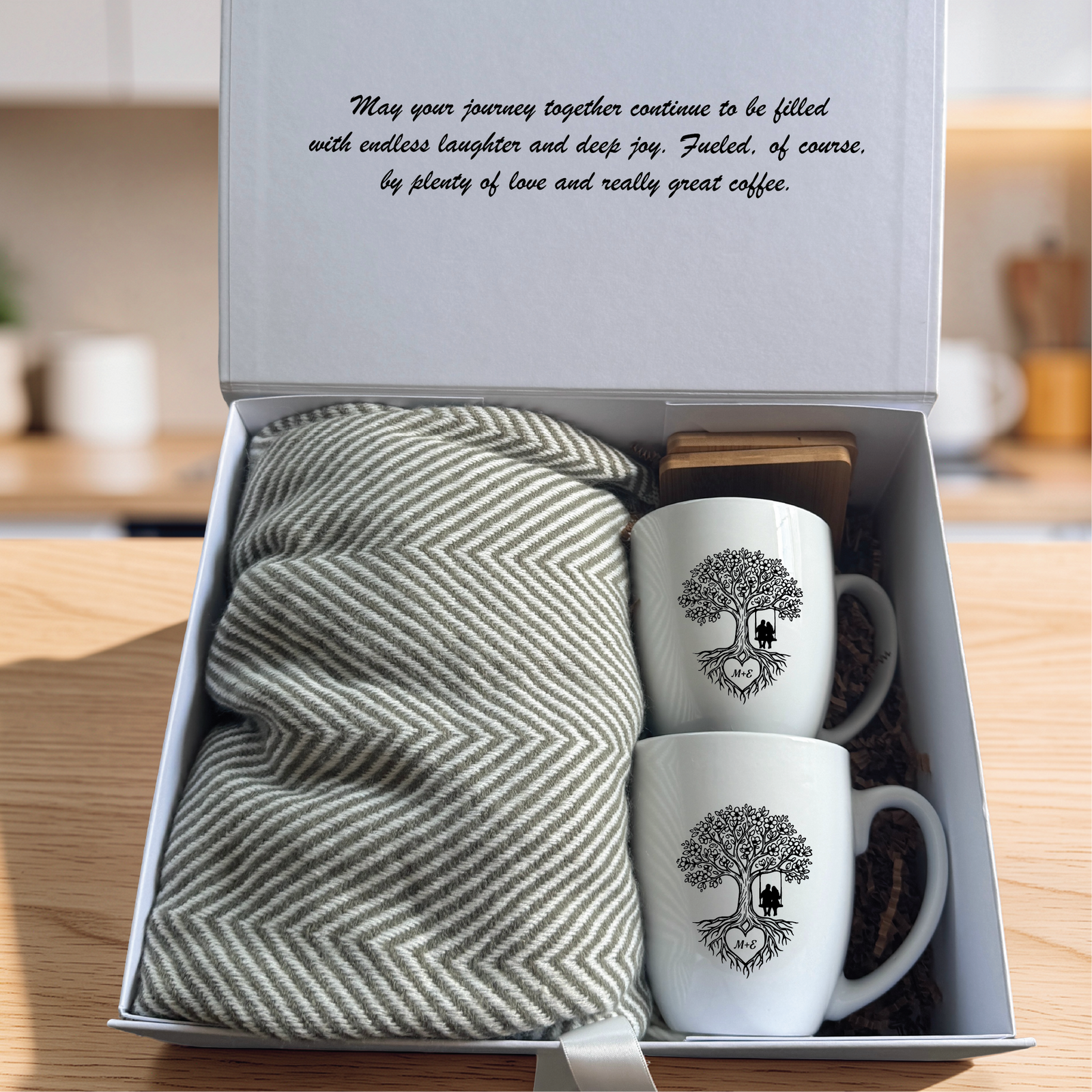 Personalized couples gift set with the script message printed inside the box lid, two engraved mugs, two bamboo coasters and a folded grey blanket.