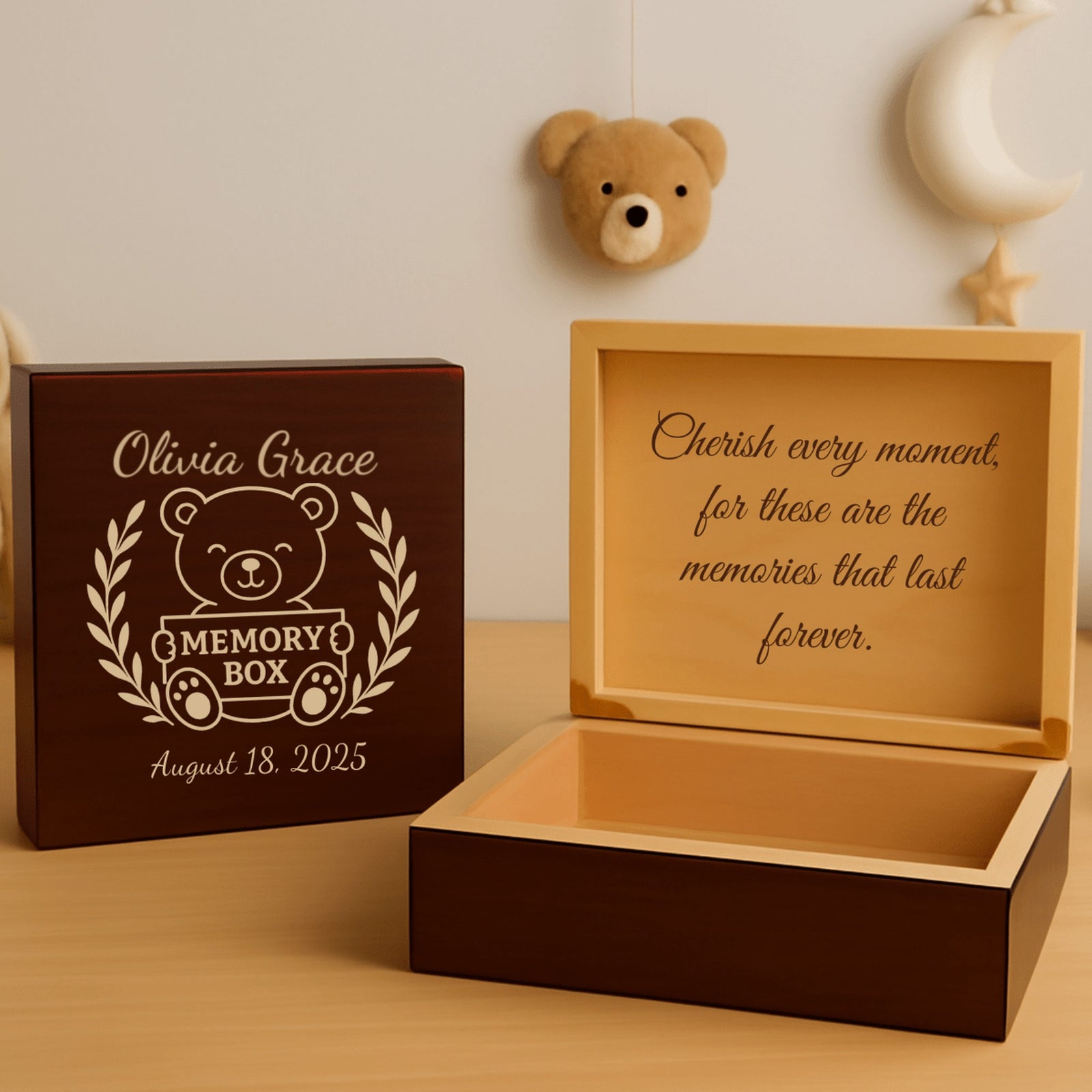 Cherry wood personalized baby keepsake box engraved with a teddy bear, laurel wreath and sample name, beside the open box with a message inside the lid