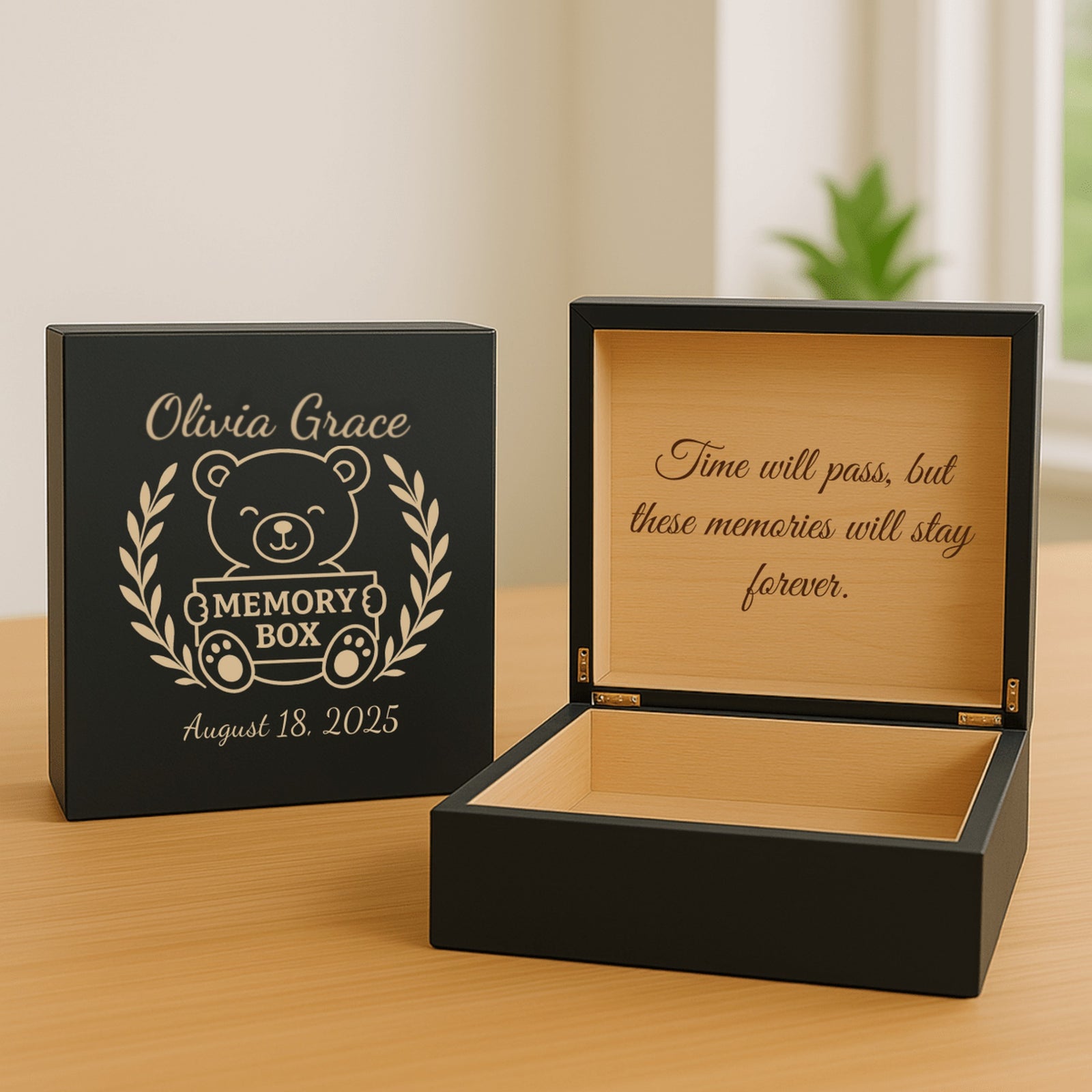 Black personalized baby memory box with the engraved teddy bear design and a sample name, shown open with a keepsake message inside the lid