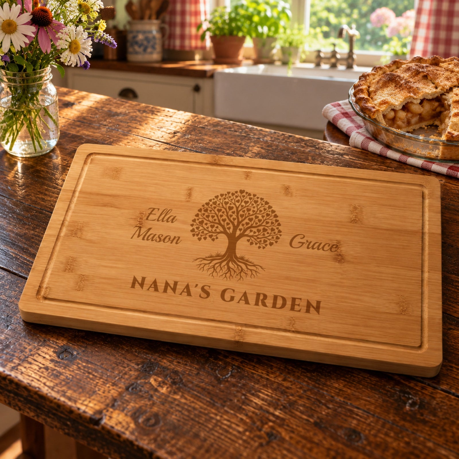 Personalized gift for grandma: bamboo cutting board engraved NANA'S GARDEN with three grandkids' names around a family tree, in a sunny kitchen with apple pie