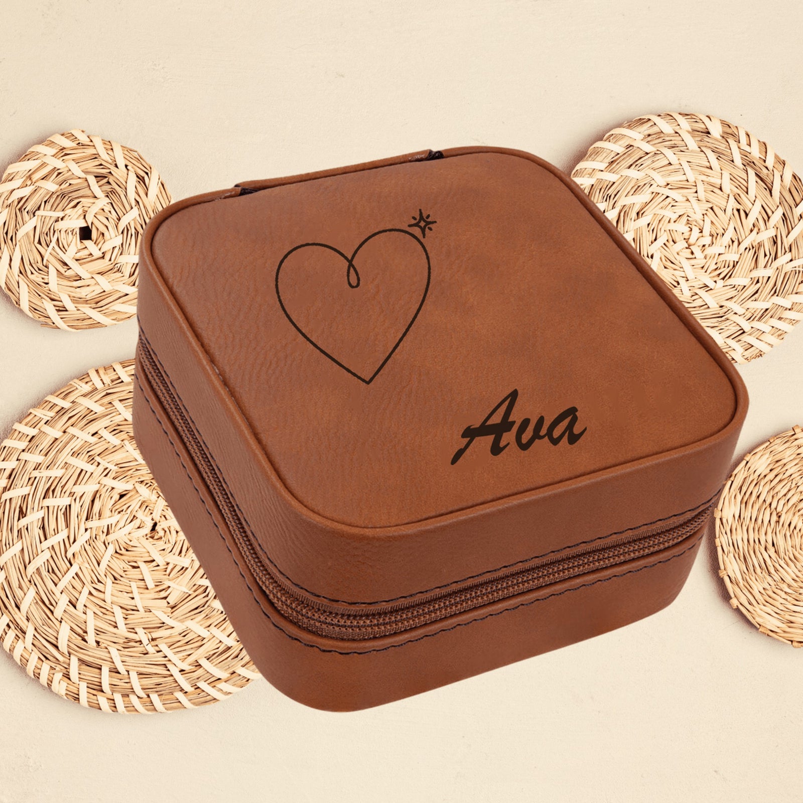 Rawhide brown personalized jewelry box engraved with a simple heart and the sample name Ava, sitting on woven coasters in a bright room