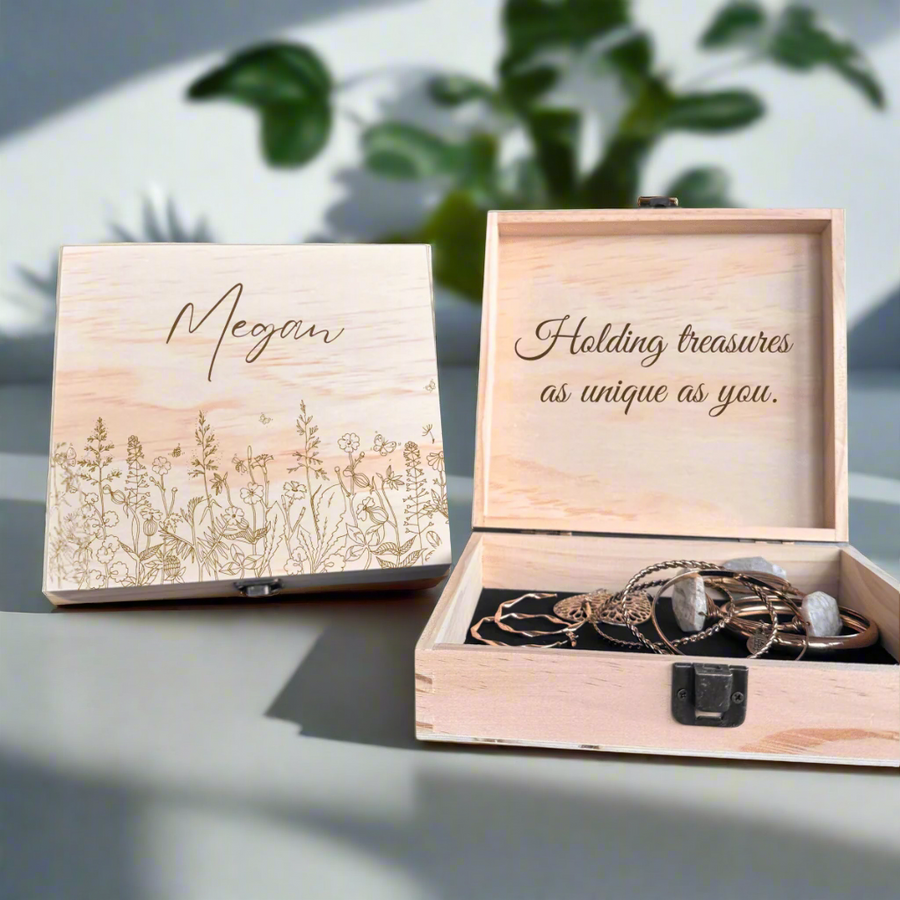 Wooden keepsake box with engraved sample name "Megan" and wildflower design on lid, open to show interior message and jewelry storage with metal clasp