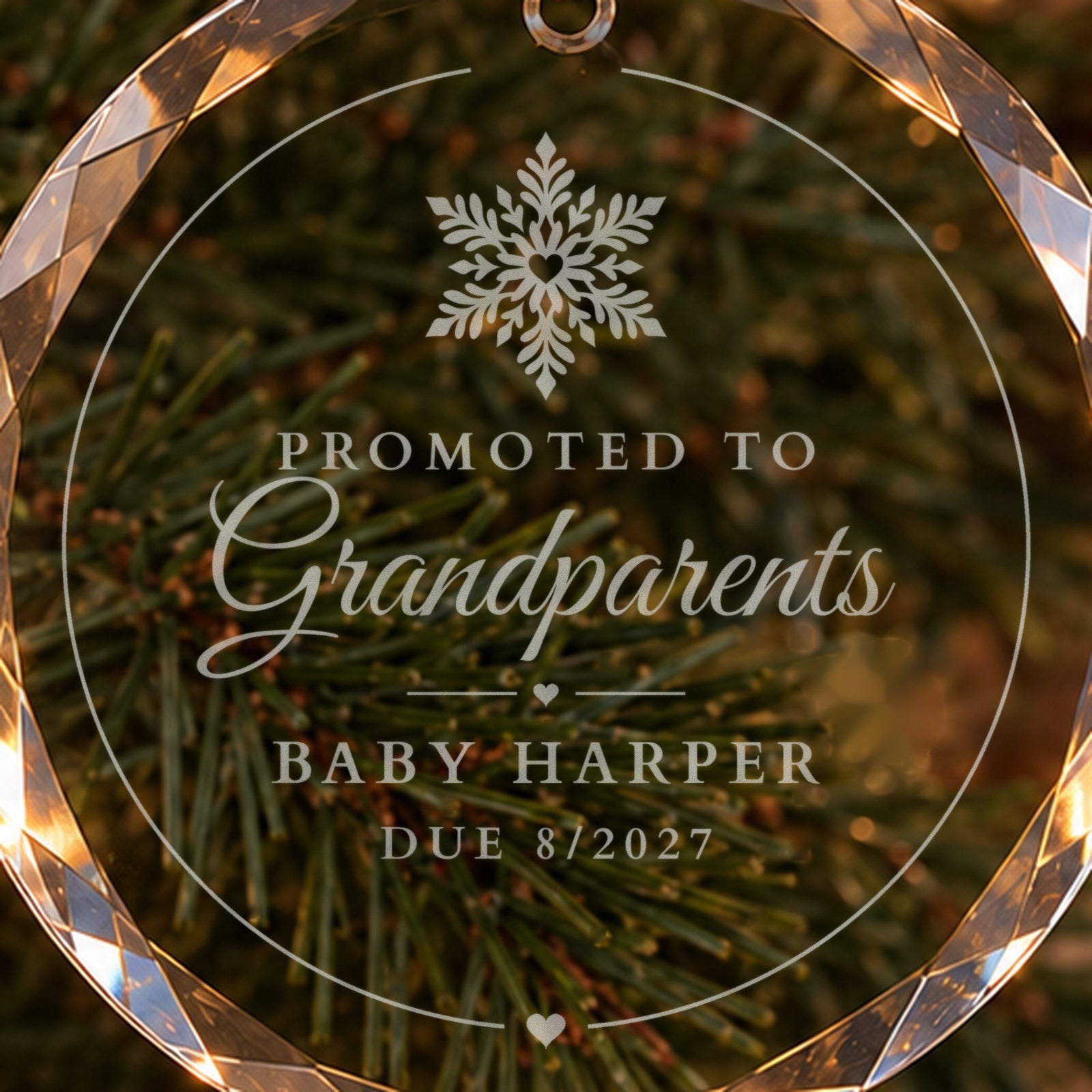 Close-up of the frosted engraving on a Promoted to Grandparents Christmas ornament: a heart snowflake above Baby Harper and Due 8/2027