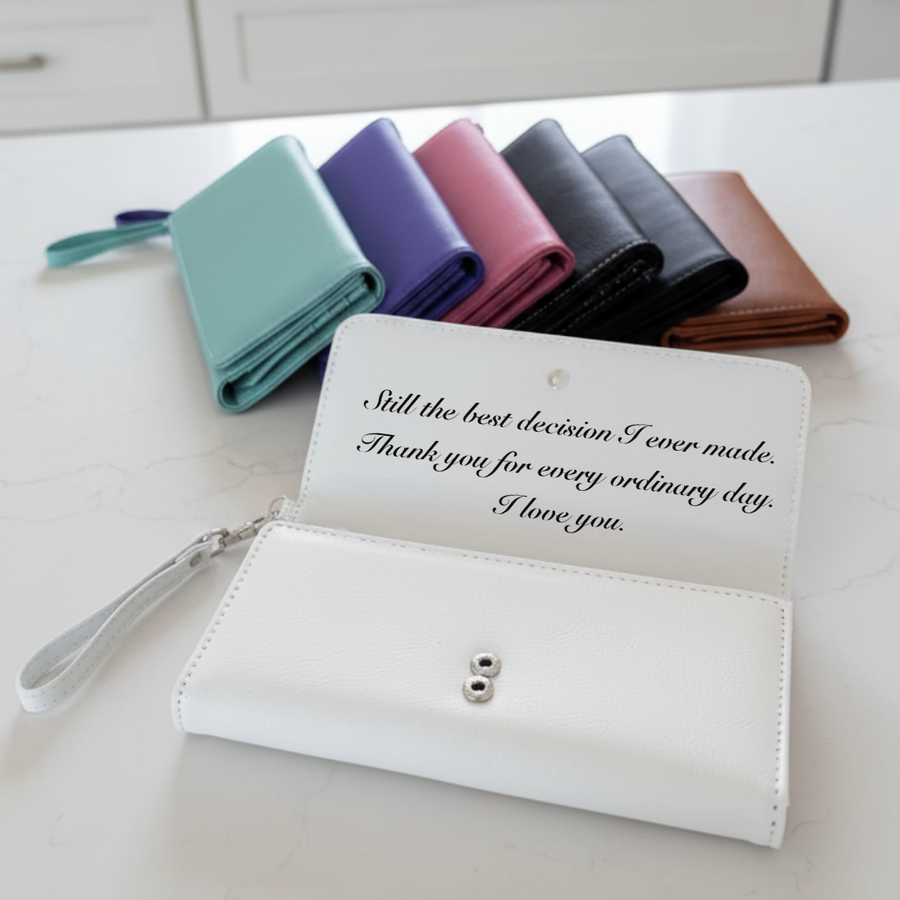 White personalized wristlet for a wife with a husband's message laser-engraved inside the flap, reading still the best decision I ever made.