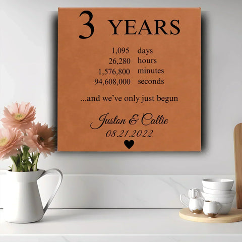Leather look wall sign engraved with 3 Years counted in days and hours above a couple’s names and wedding date, one of 18 personalized leather third anniversary gifts for her