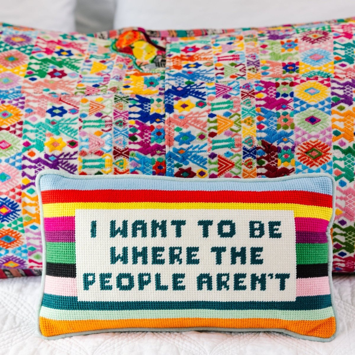 I Want to Be Where the People Aren’t needlepoint pillow, 8x14 inches, featuring wool embroidery and a cotton velvet back, a witty and cozy accent.
