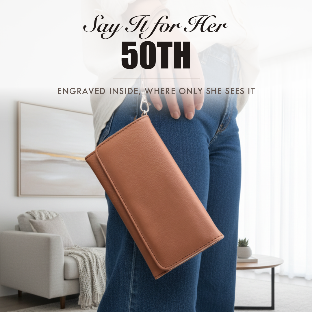 Brown faux leather wristlet held by a woman, captioned Say It for Her 50th, shown as a personalized 50th birthday gift for her.