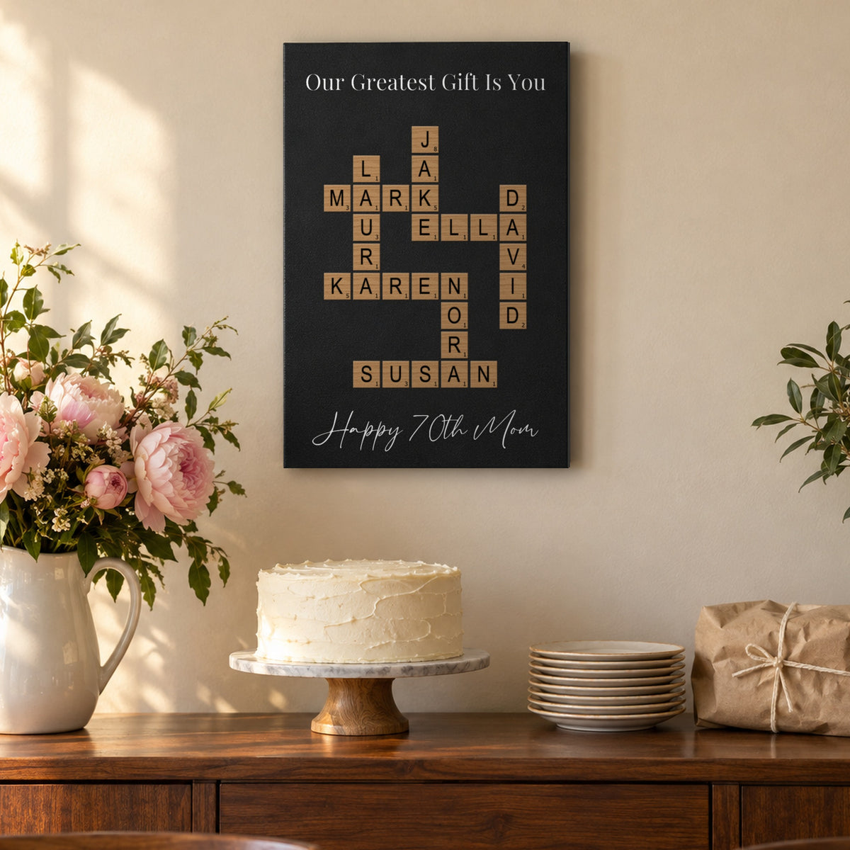 70th birthday gift for Mom: an Our Greatest Gift Is You crossword sign with Happy 70th Mom above a birthday cake and pink peonies