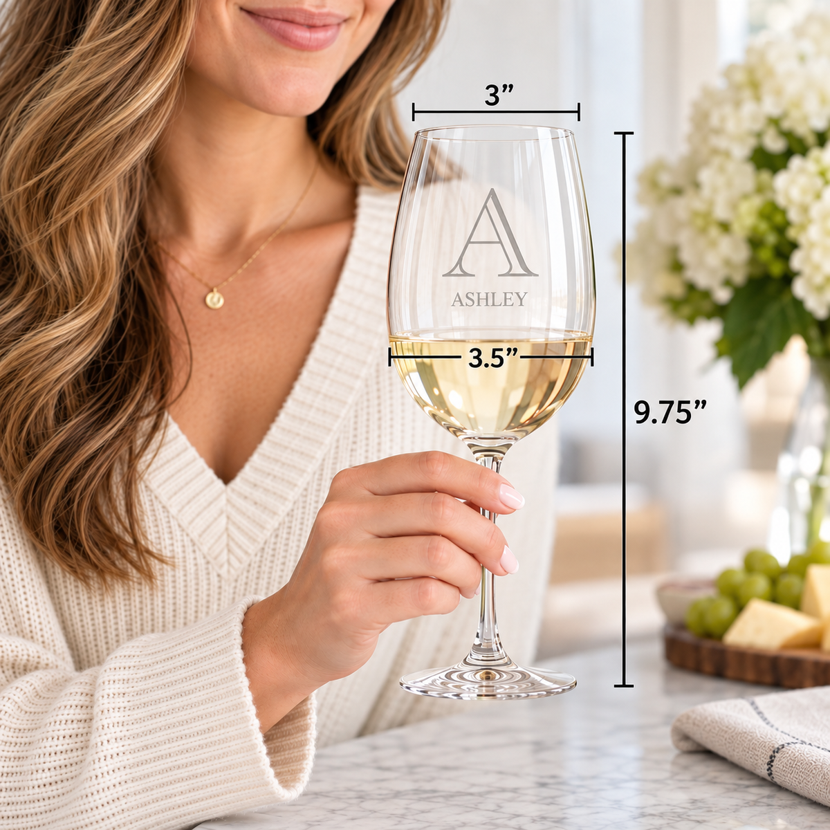 Engraved wine glass with sample name "Ashley" shown with sample dimensions: 3" width, 3.5" bowl, 9.75" height, filled with white wine