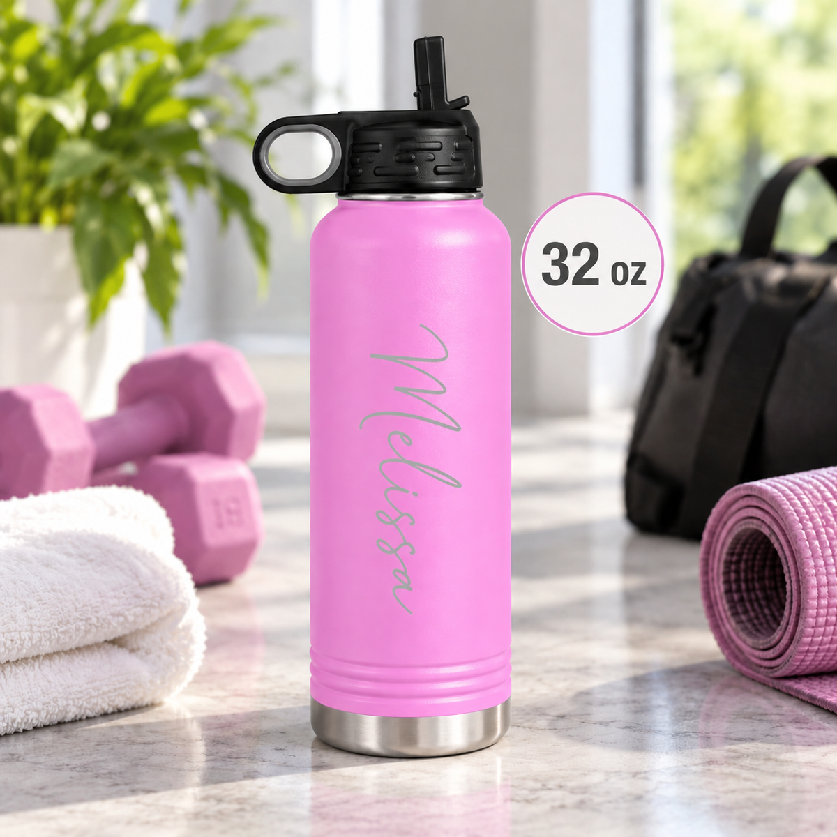 Light blue insulated water bottle laser engraved with the name Kaleigh in script, outdoors on a wooden table.