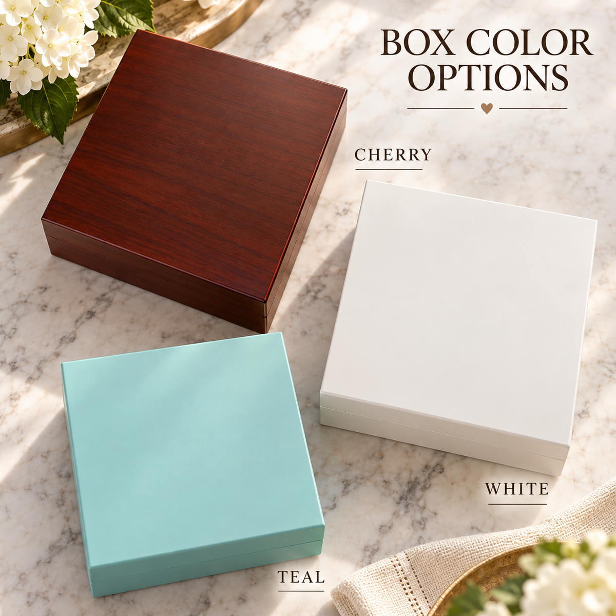 Keepsake boxes in cherry wood, white, and teal finishes arranged on marble with floral styling and color labels