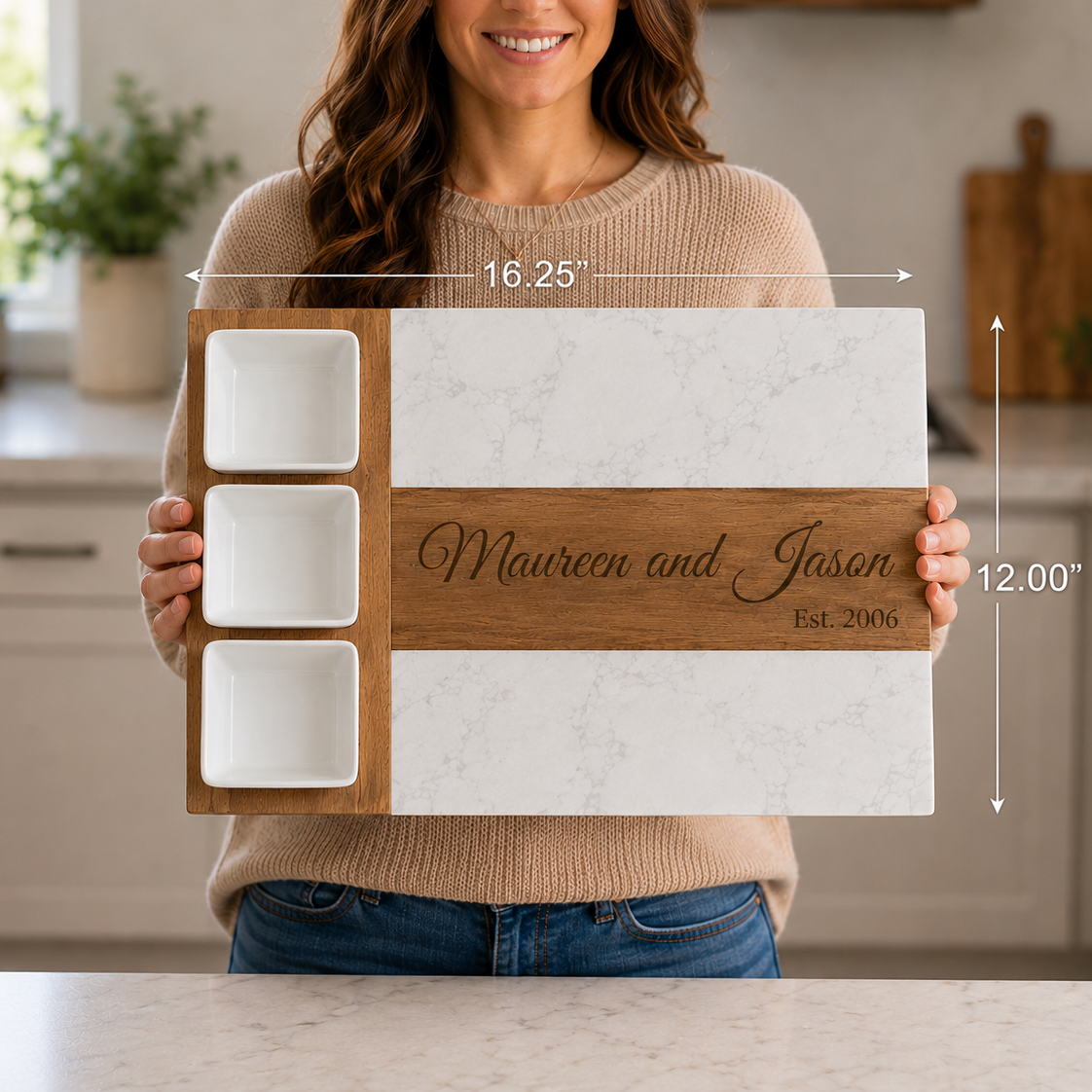 Woman holding the personalized marble and acacia wood anniversary charcuterie board in a kitchen, with dimension arrows showing 16.25 inches wide by 12 inches tall.
