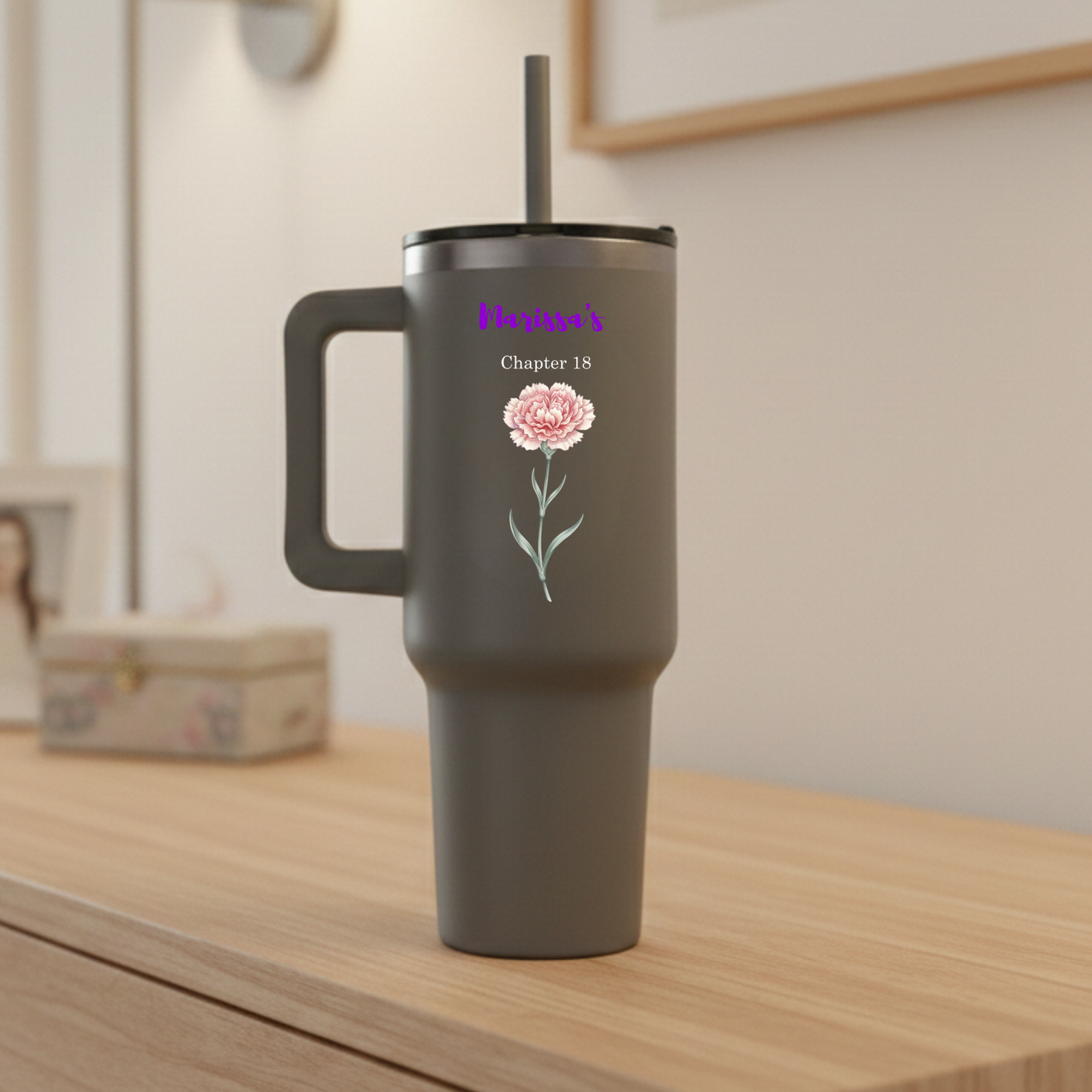 Three personalized tumblers with floral designs on a kitchen counter.