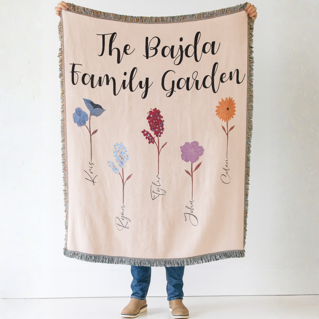 Personalized blanket with floral designs with family garden and childrens names on a bed in a bedroom setting
