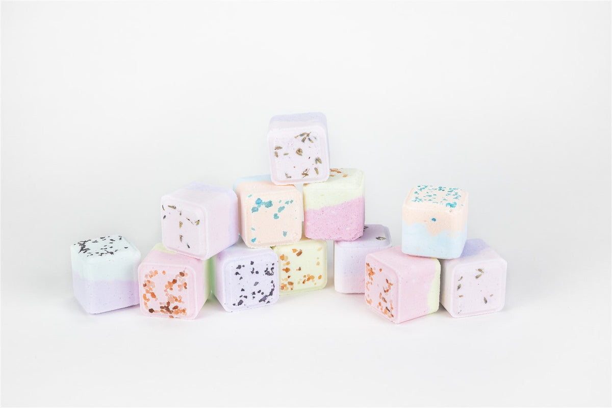 Pastel-colored bath bombs stacked on a white background