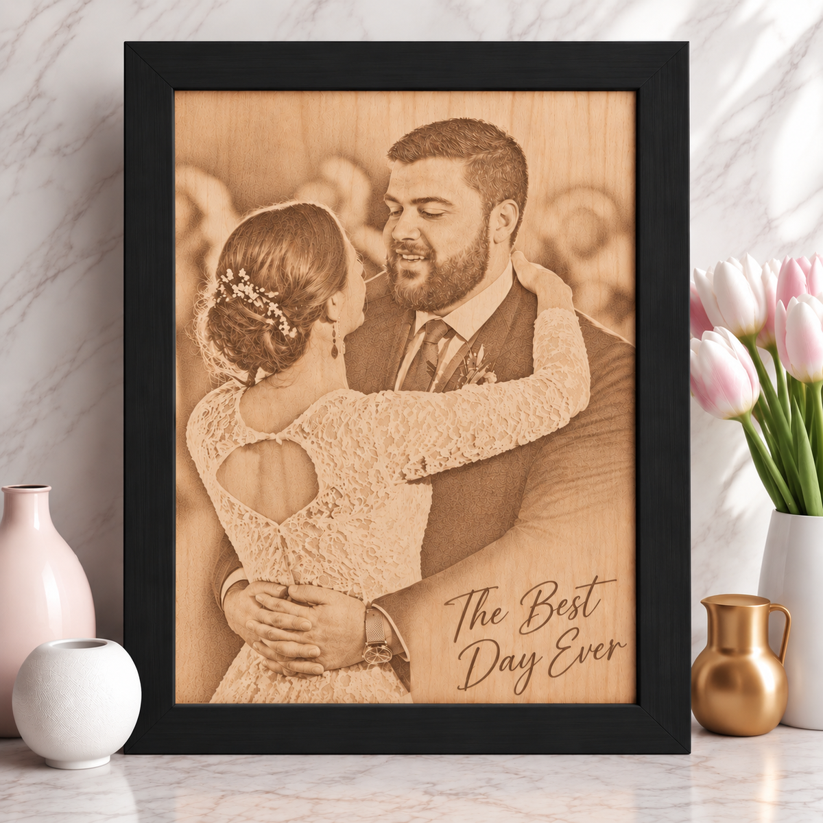 Black wood frame with a laser-etched wedding photo of a bride and groom embracing, with 'The Best Day Ever' engraved in the bottom corner instead of a name and date.
