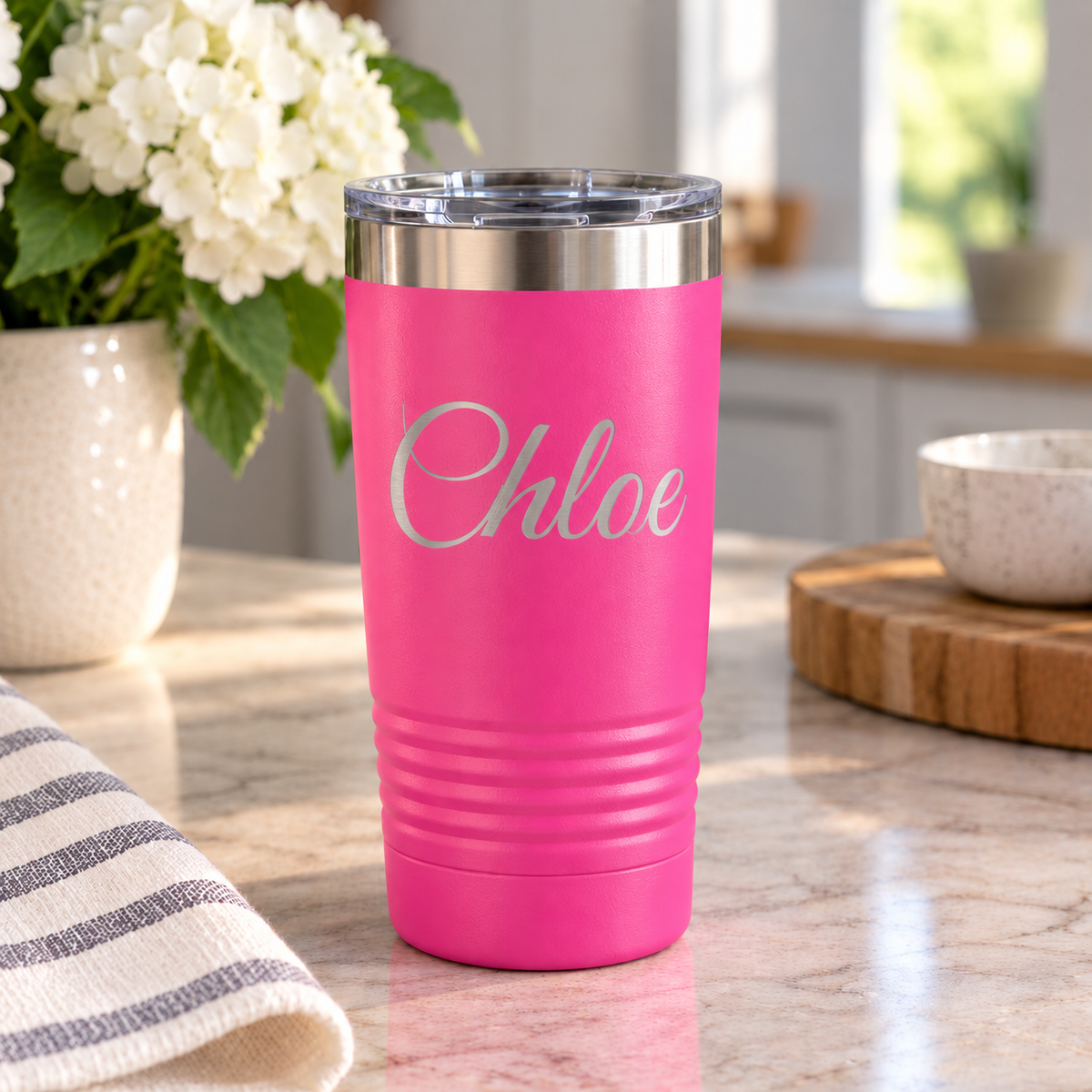 hot pink. tumbler sitting on counter with Chloe laser engraved on it. 