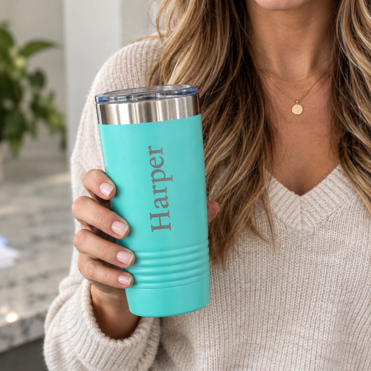 Nine personalized insulated coffee tumblers in different colors including navy, teal, white, and pink, engraved with names including JoJo, Cara, and Riley, on a marble counter.
