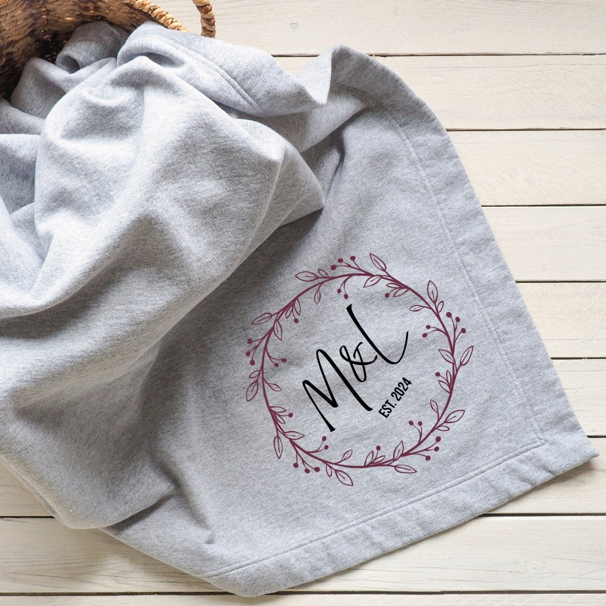 Gray blanket featuring a couple's initials and "Est. [Year]" in a decorative wreath design.