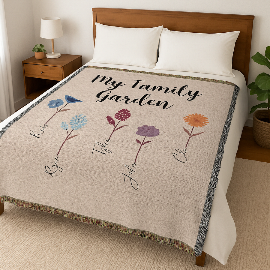 Personalized blanket with floral designs with family garden and childrens names on a bed in a bedroom setting