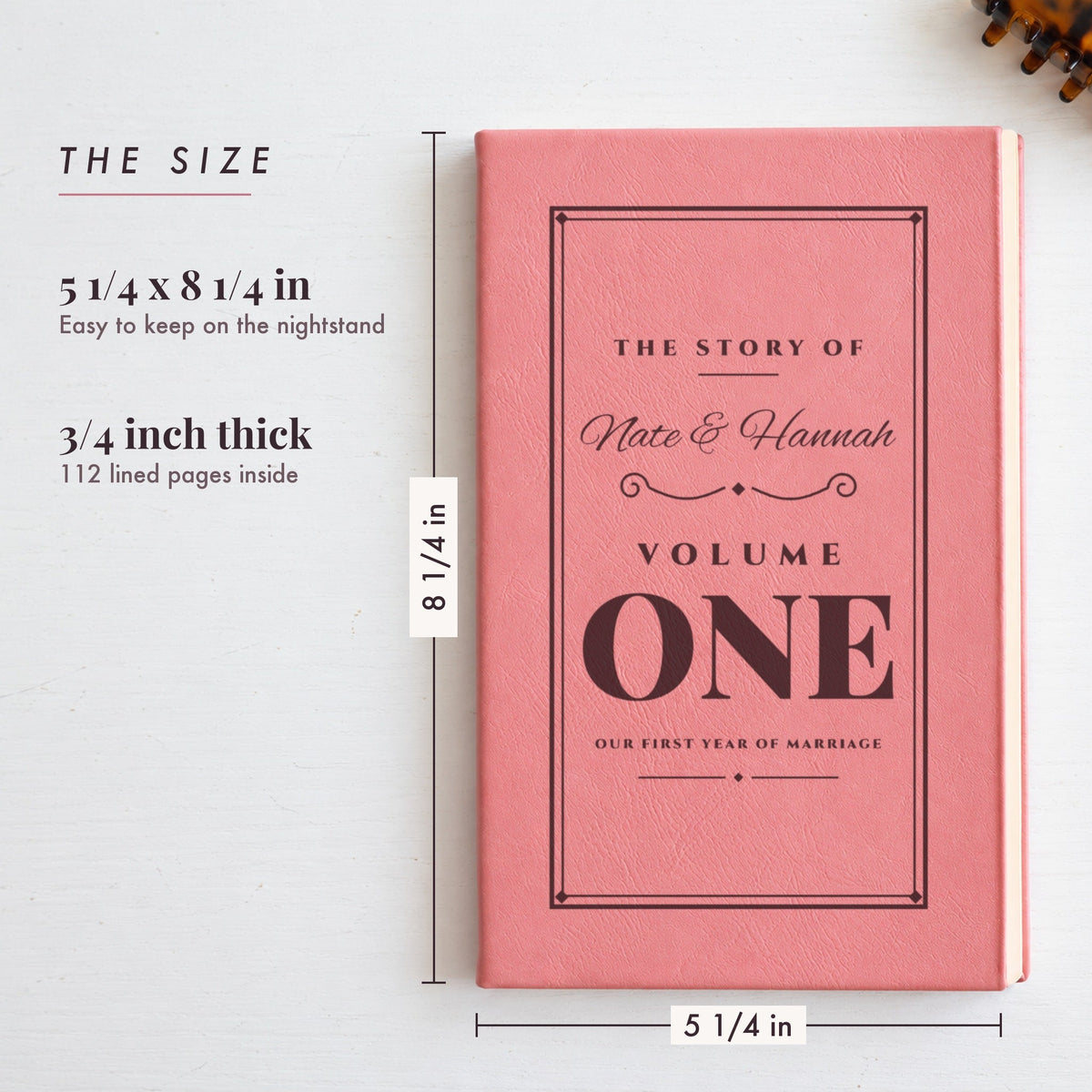 Size of the personalized anniversary journal, 5 1/4 by 8 1/4 inches and 3/4 inch thick, shown in pink engraved for Nate & Hannah