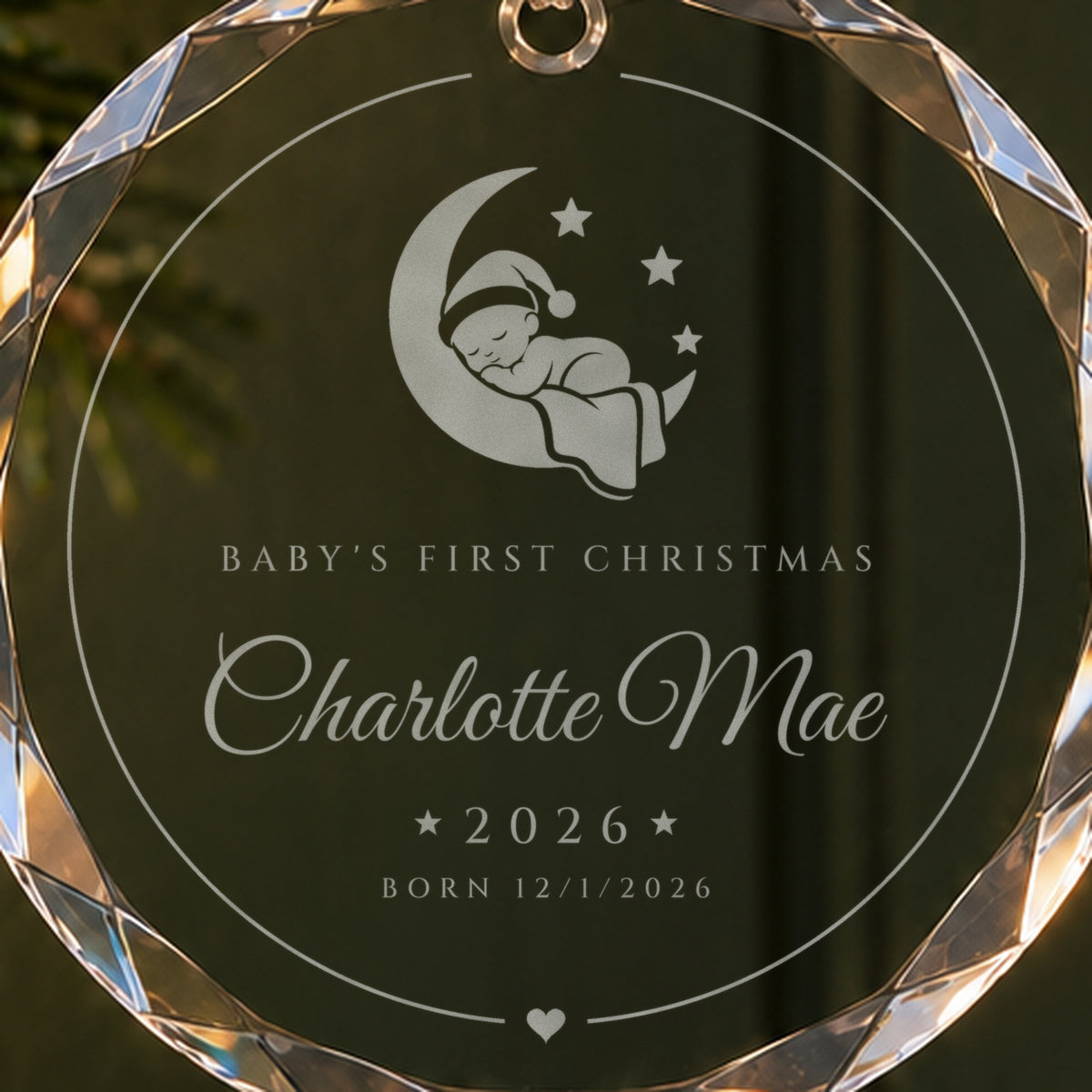Close-up of the frosted moon baby engraving on the baby's first Christmas ornament, with Charlotte Mae, 2026 and Born 12/1/2026