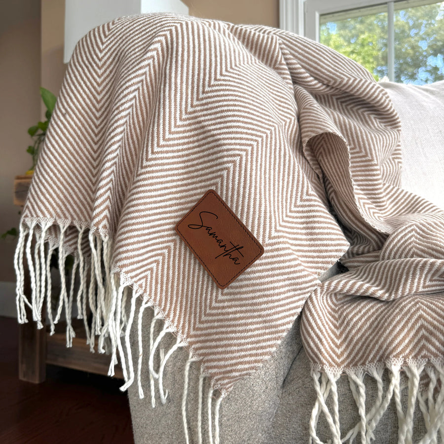 Custom personalized throw blanket with an engraved leather name patch