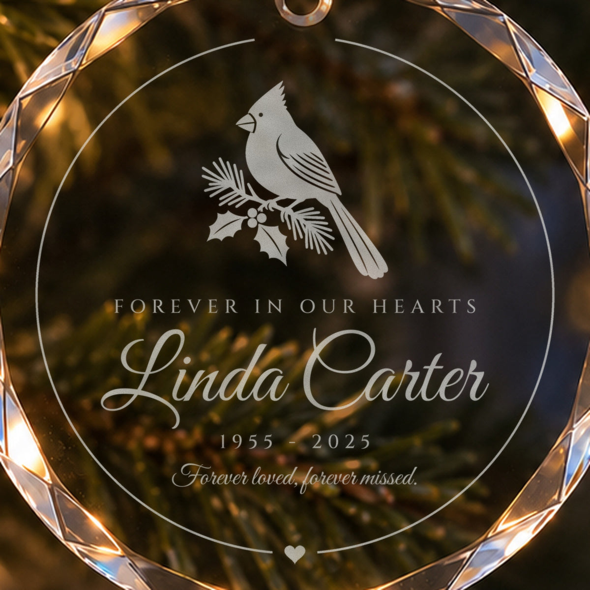 Close-up of the frosted cardinal engraving on the memorial Christmas ornament: pine and holly bough, Forever in Our Hearts, Linda Carter, 1955 - 2025
