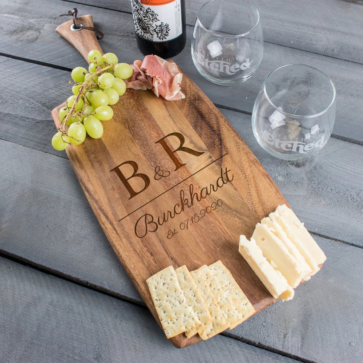 Wedding Date Charcuterie Board in acacia wood with leather strap, 20.5 by 8 inches, engraved with wedding date and couple's names