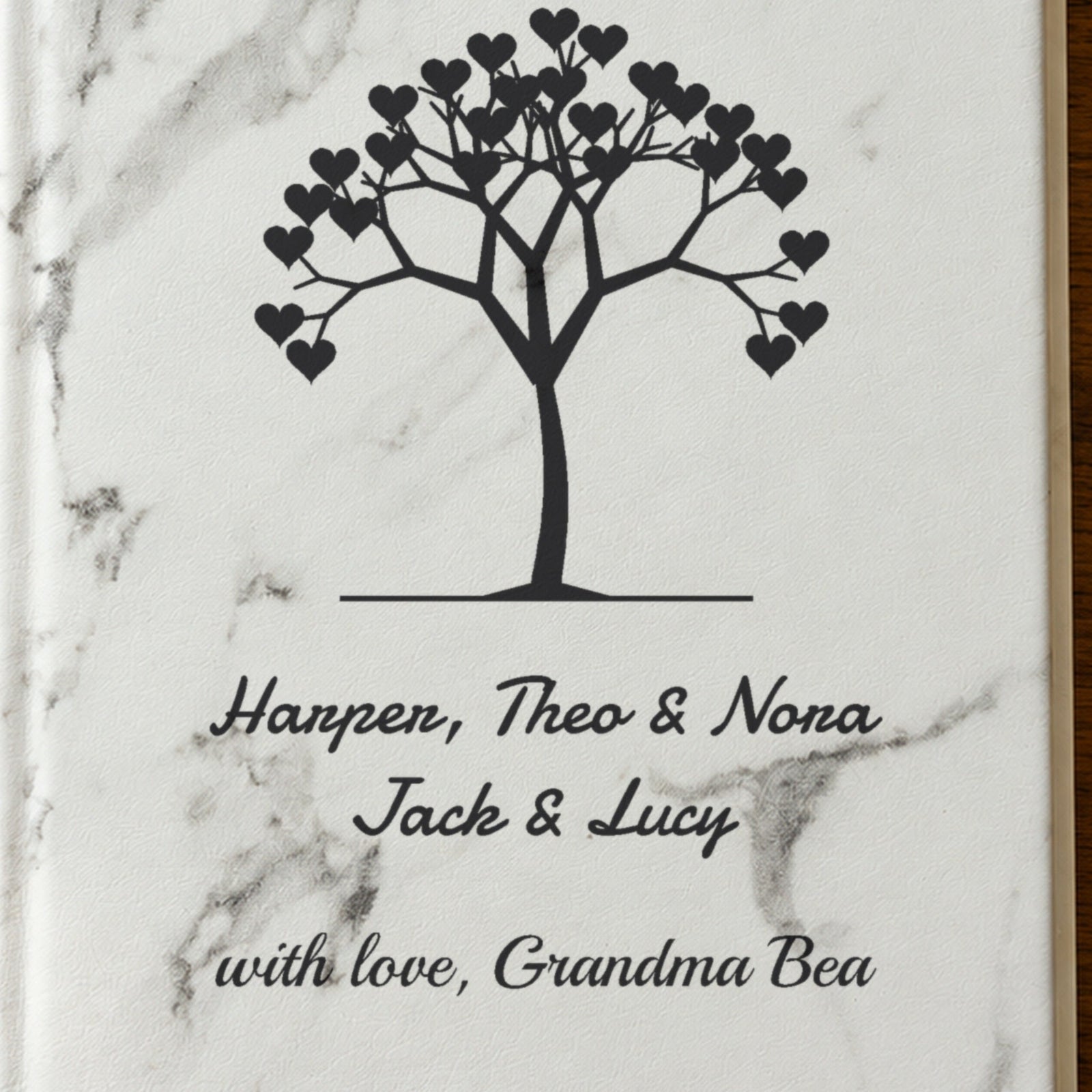 Close-up of the laser engraving on the white marble grandma journal: a tree of hearts above Harper, Theo & Nora, Jack & Lucy and with love, Grandma Bea