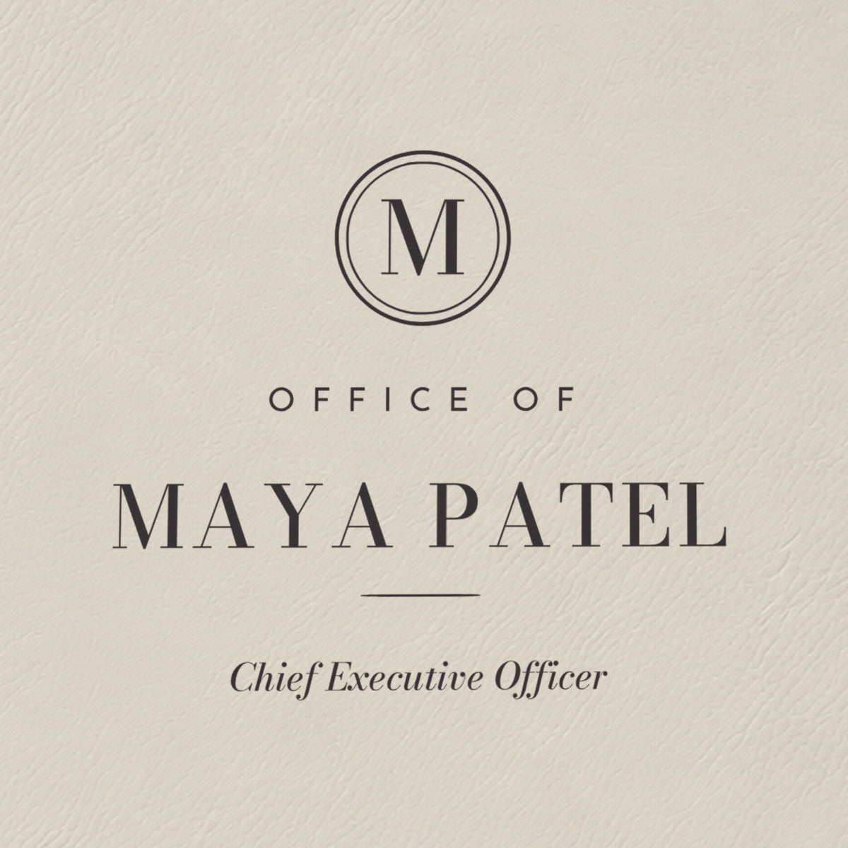 Close-up of the black laser engraving on the white padfolio: M monogram seal, Office of, Maya Patel and Chief Executive Officer in italic