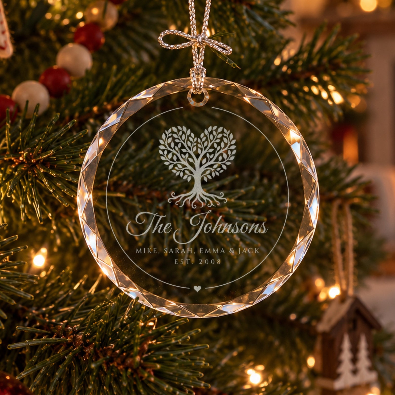 Personalized family tree ornament in faceted glass on a Christmas tree by the fireplace, engraved with a heart tree, The Johnsons and four first names