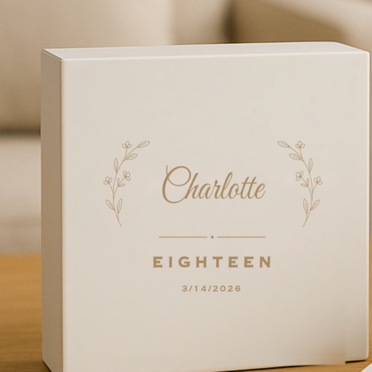 White personalized keepsake box engraved with the name Charlotte in script between two botanical sprigs, above the word EIGHTEEN and the date 3/14/2026.