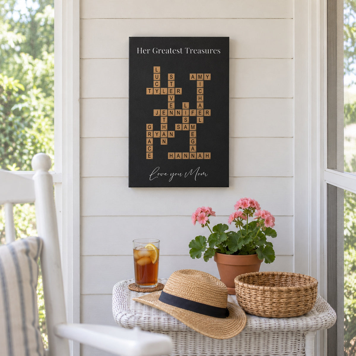 Gift for a 70 year old woman: a Her Greatest Treasures crossword sign with 13 family names hanging on a white summer porch wall