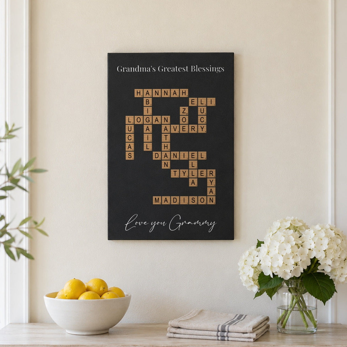 Gift for Grandma from the grandkids: a Grandma's Greatest Blessings crossword sign with 14 grandkids' names above a white dining sideboard