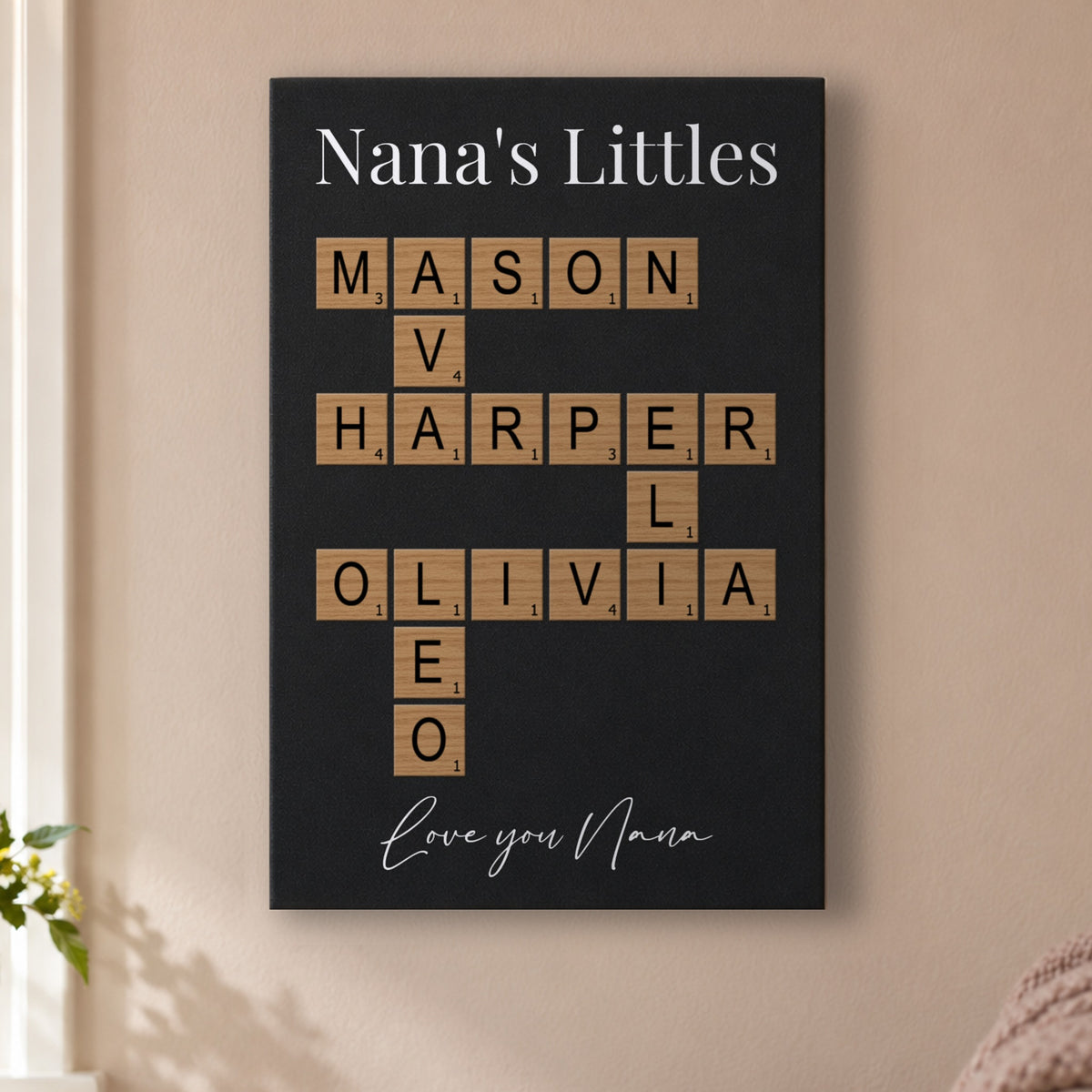 Grandkids crossword sign for Grandma: a Nana's Littles sign with the grandkids' names and Love you Nana, hanging on a blush wall in a cozy living room