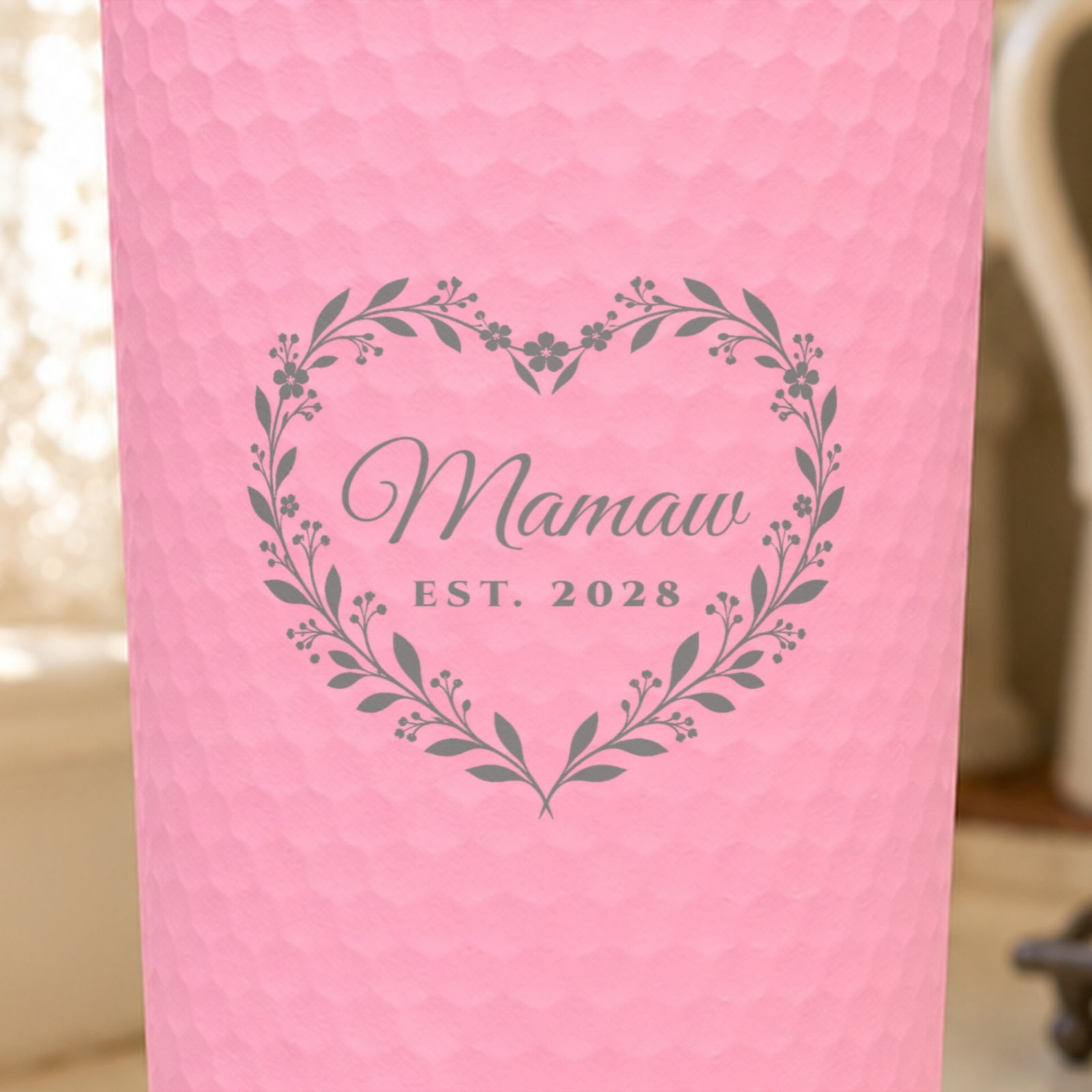 Close-up of the laser engraving on a pink dimpled tumbler: a leafy heart wreath around the name Mamaw and EST. 2028